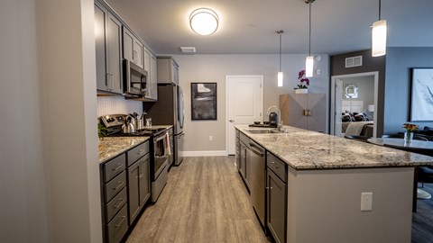 A modern kitchen with a center island and stainless steel appliances.