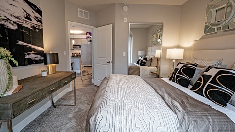 A bedroom with a large bed and a painting on the wall.