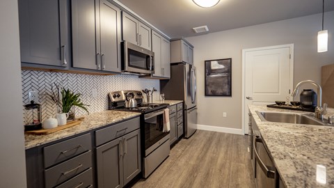 A kitchen with dark cabinets and a white door.