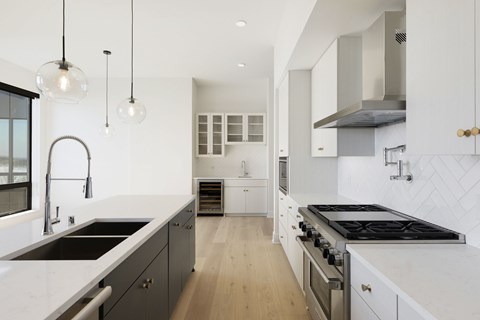 A modern kitchen with a stove top oven and a sink.