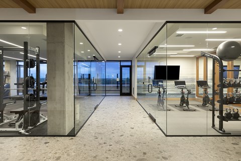 A modern gym with a glass wall and a television.