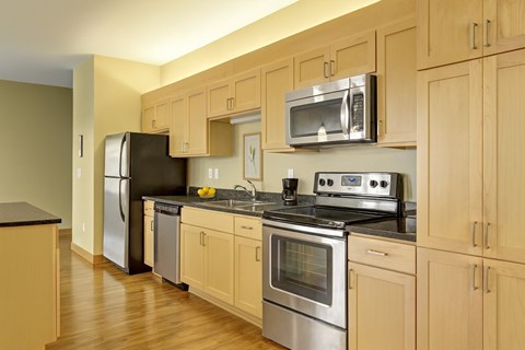 A kitchen with wooden cabinets and stainless steel appliances.