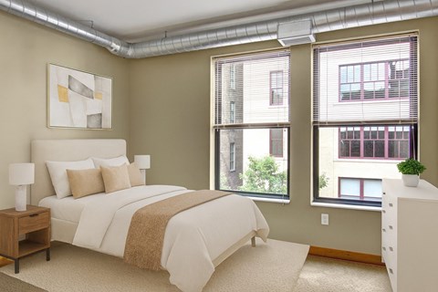 A bedroom with a large bed and a window with a view of a building.