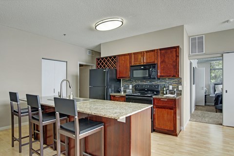 A kitchen with wooden cabinets and a granite countertop.