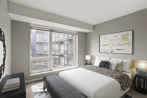 Modern bedroom here at Maverick with a white bed, patterned throw, dark bench, large window, and wall art in a neutral-toned room.