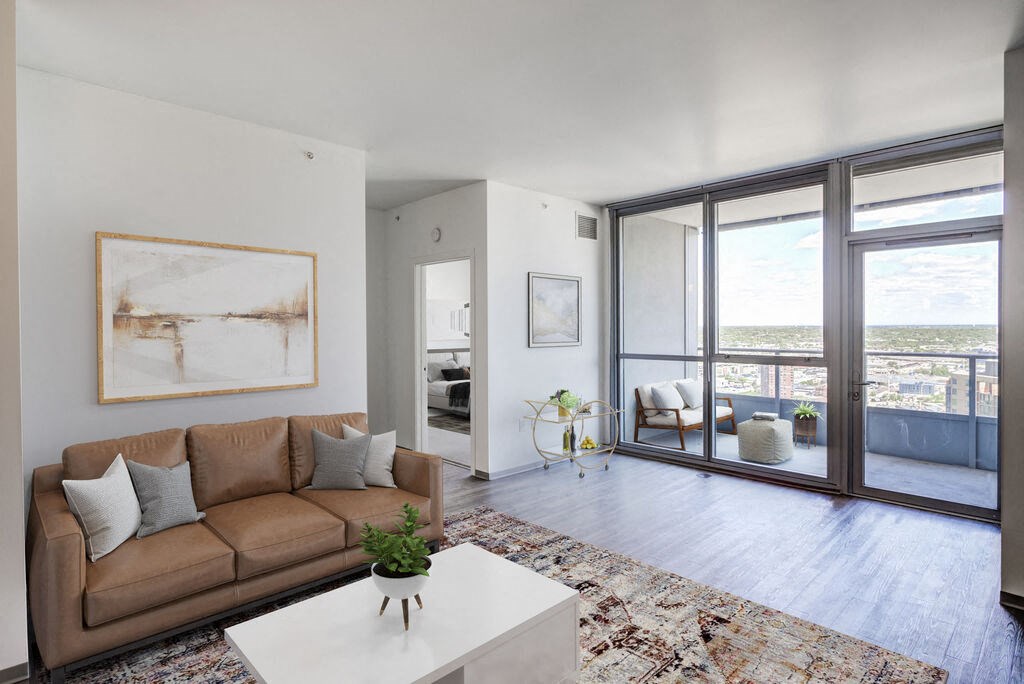 a living room with a brown couch and a white coffee table