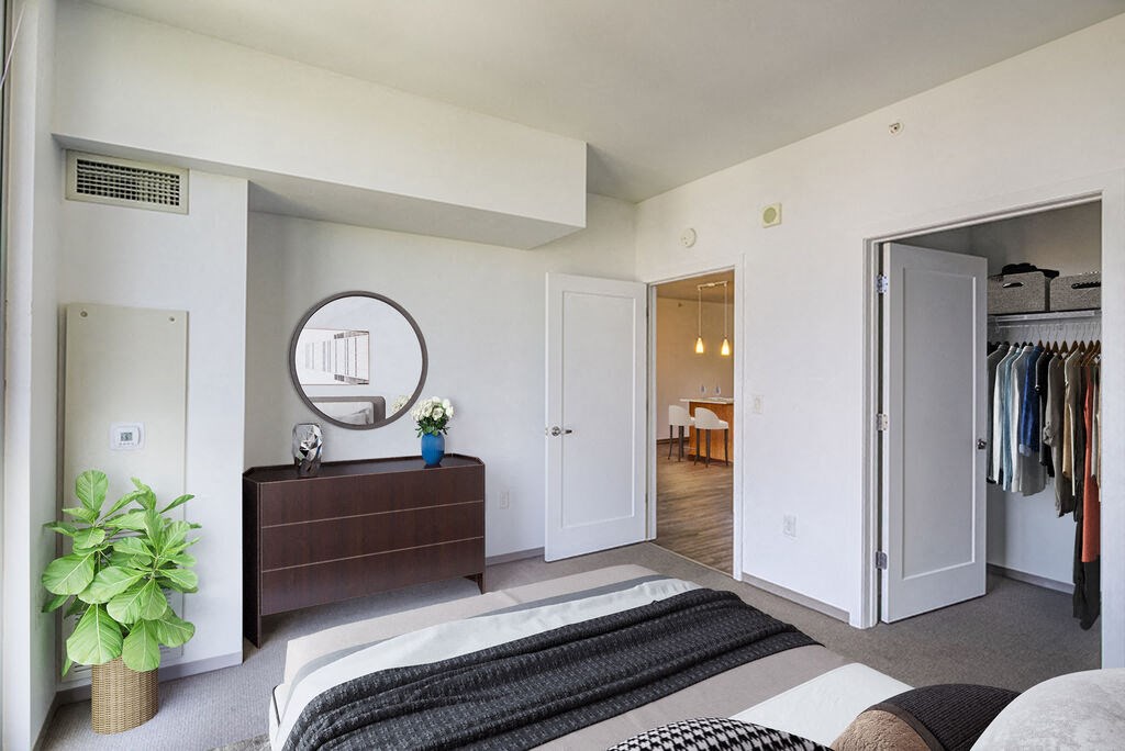 a bedroom with white walls and a black and white bedspread