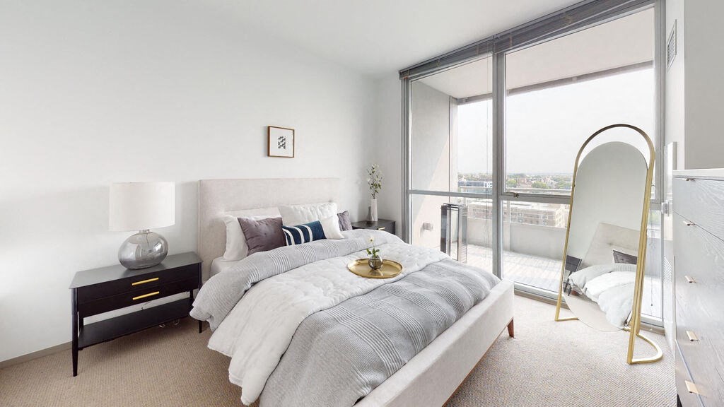 a bedroom with a bed and a large window