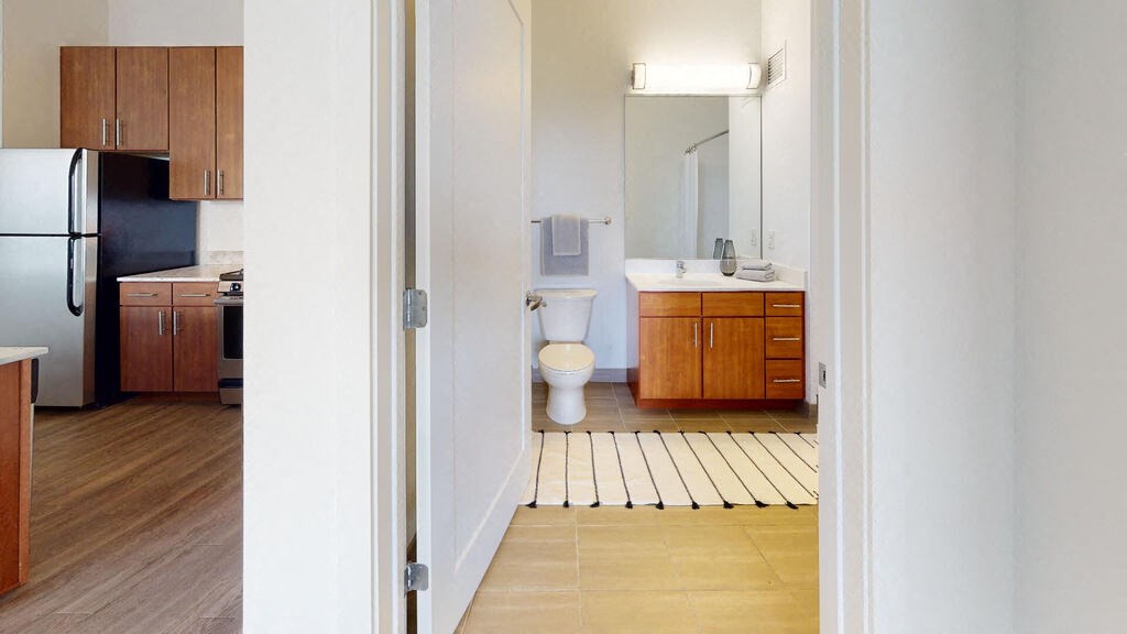 a bathroom with a toilet sink and refrigerator