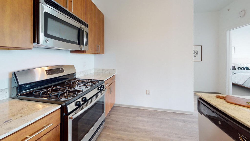 a kitchen with wood cabinets and stainless steel appliances