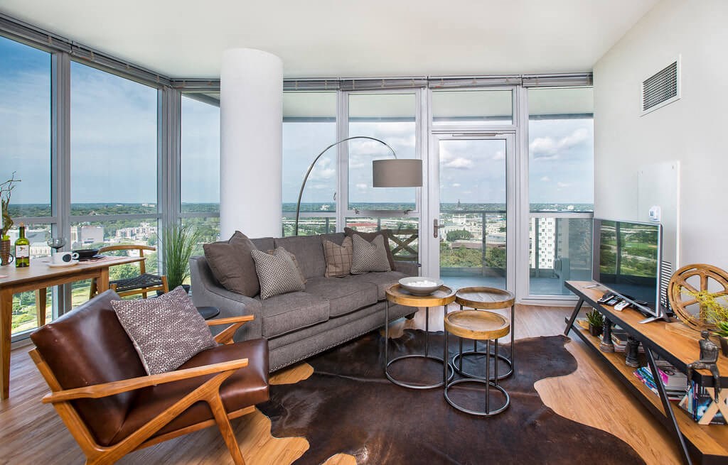 a living room with a gray couch and a large window