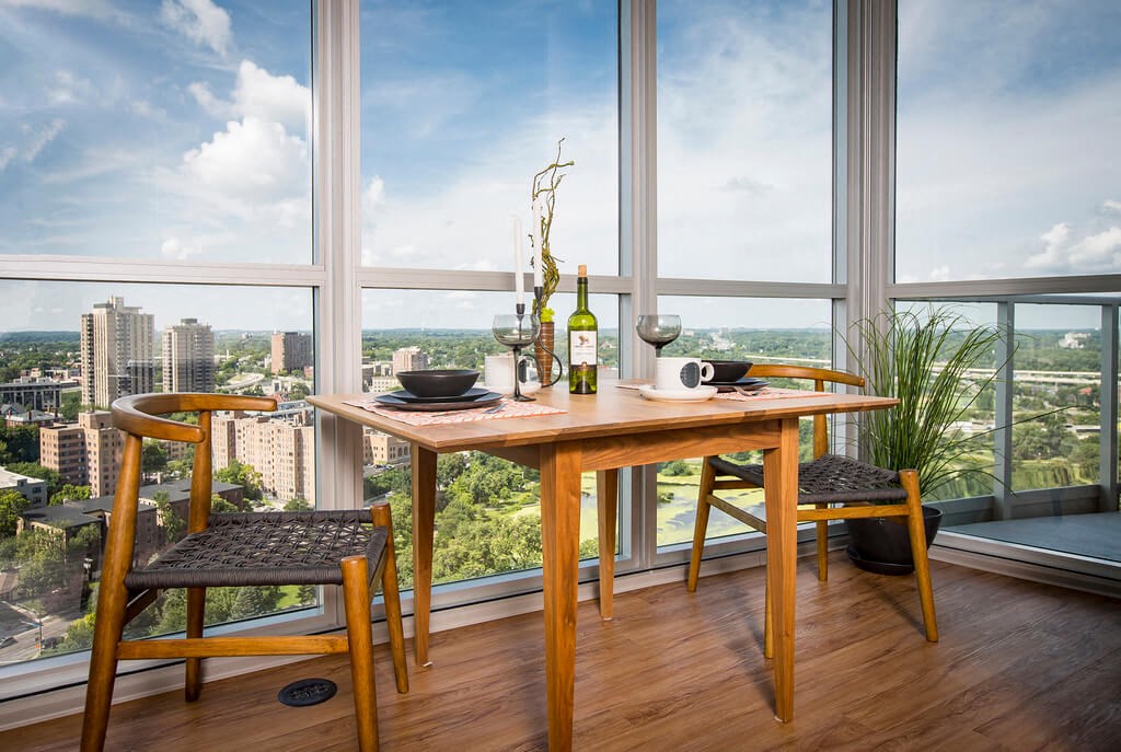 a dining table with two chairs and a bottle of wine on top of a table with a