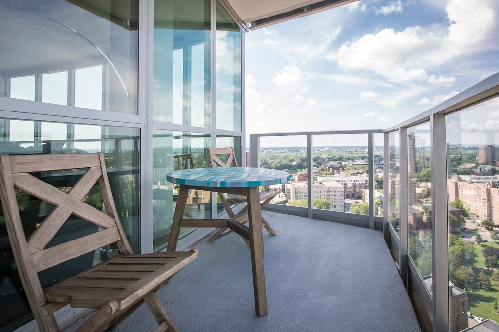 a balcony with a table and two chairs and a view of the city