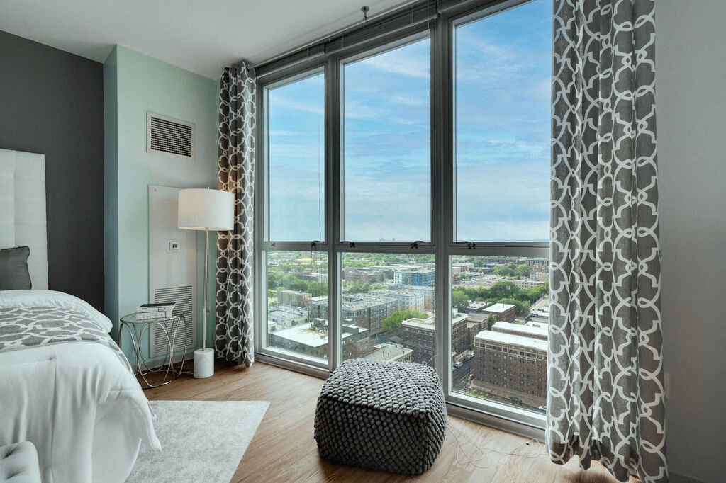 a bedroom with a bed and a large window