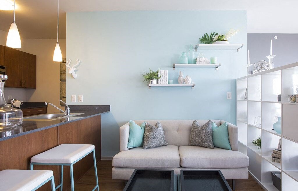 a living room with a couch and a kitchen in the background