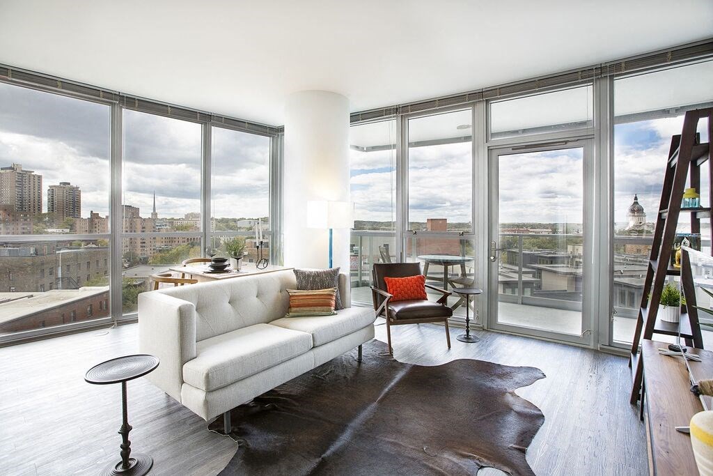 a living room with a white couch and large windows