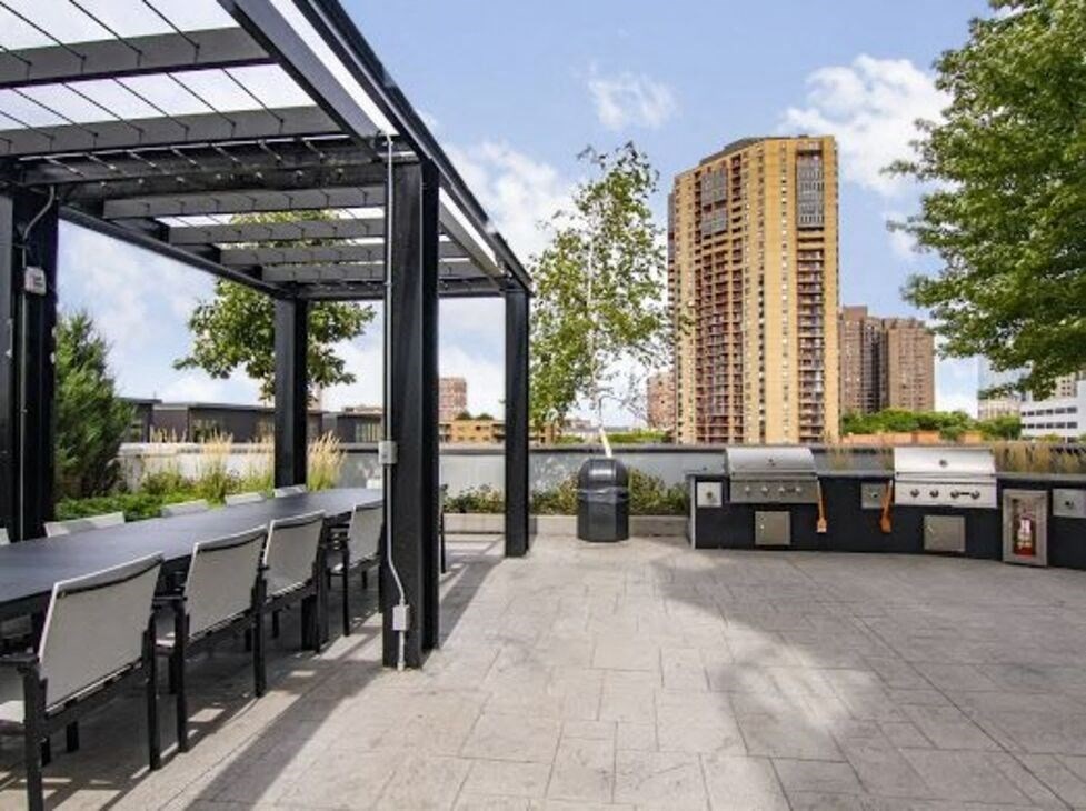 a patio with a grill and a table and chairs