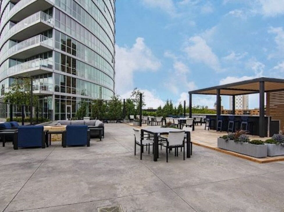 a large patio with tables and chairs and a building in the background
