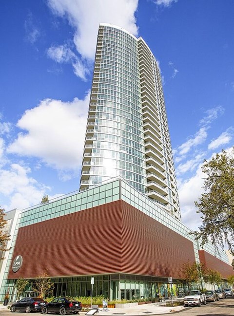 A modern building with a glass facade and a red roof.