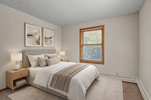 A bedroom with a bed, nightstands, and pictures on the wall.
