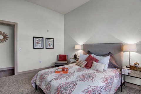A bedroom with a large bed and a chair.