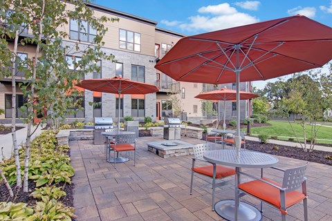 A patio with a table and chairs under an umbrella.