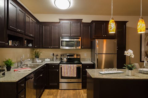 A kitchen with dark wood cabinets and stainless steel appliances.