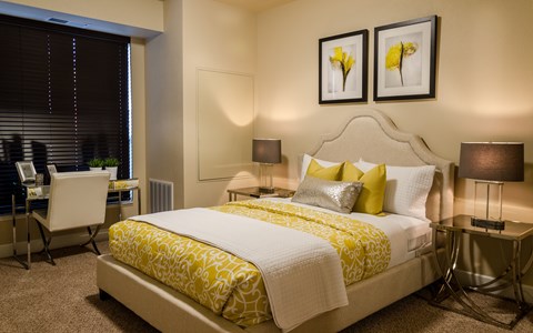 A bedroom with a large bed and two lamps.