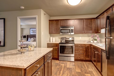 A kitchen with wooden cabinets and a granite countertop.