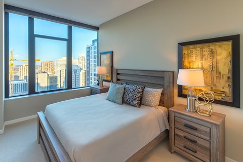 A bedroom with a large bed and a view of the city.