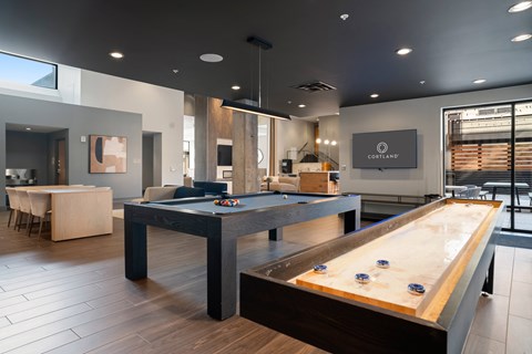 A pool table in a room with a sign that says "CORTELAND".
