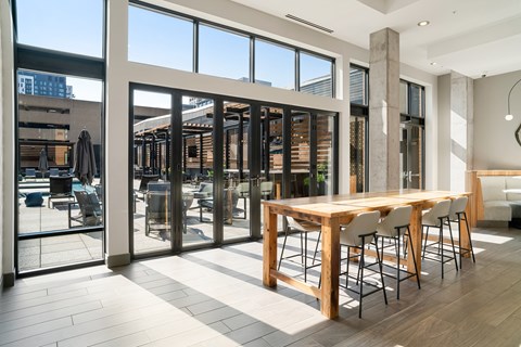 A modern dining room with a long wooden table and chairs.
