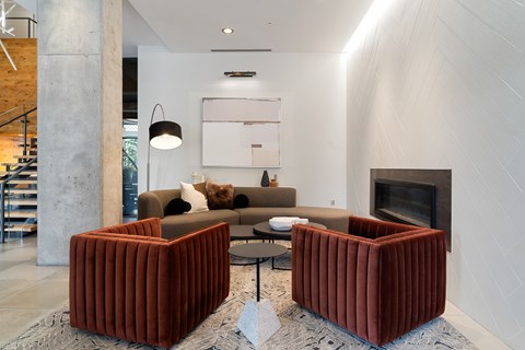 A living room with a grey couch and a fireplace.