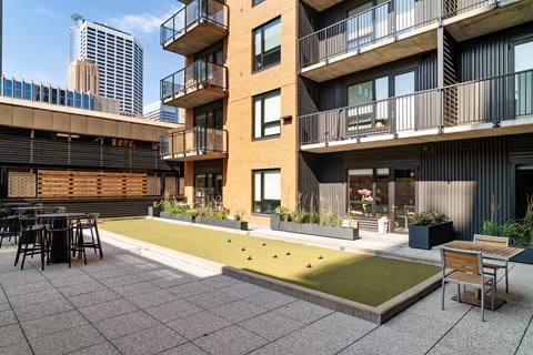 A modern building with a balcony and a small garden area.
