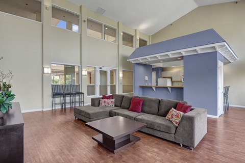 A living room with a grey couch and a wooden coffee table.