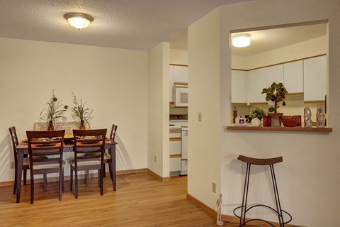 A kitchen with a dining table and chairs.
