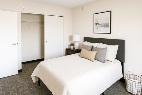 A bedroom with a large bed and a painting on the wall.