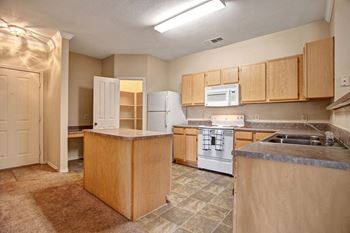 an empty kitchen with a stove and a microwave