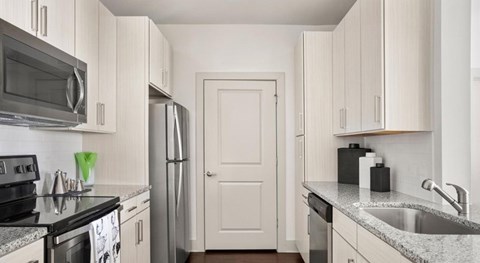 A kitchen with white cabinets and a black stove top.