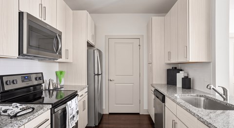 A kitchen with white cabinets and a black stove top.