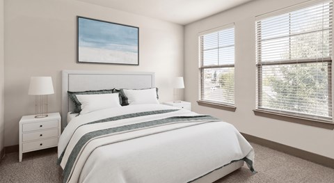 A bedroom with a large bed, a nightstand, and a window with blinds.