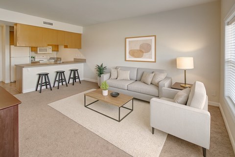 A living room with a white couch, a coffee table, and a painting on the wall.