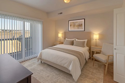 A bedroom with a large bed and a chair.