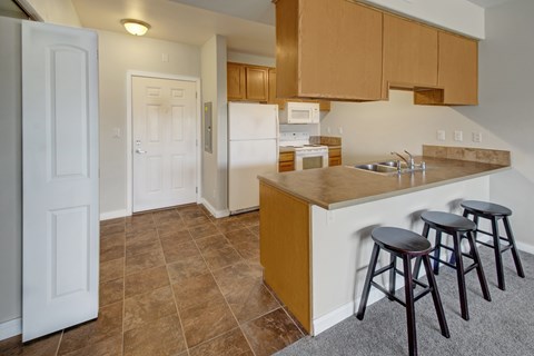 A kitchen with brown cabinets and white walls.