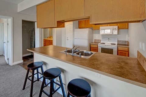 A kitchen with a white refrigerator, a white oven, and a white microwave.