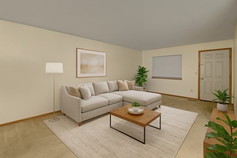 A living room with a grey couch, a coffee table, and a painting on the wall.