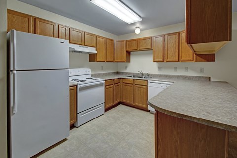 A kitchen with wooden cabinets and a white refrigerator.