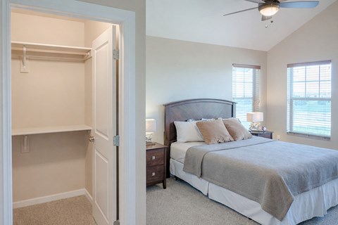 A bedroom with a large bed and a ceiling fan.