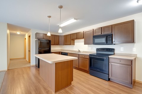 A kitchen with brown cabinets and a white island.