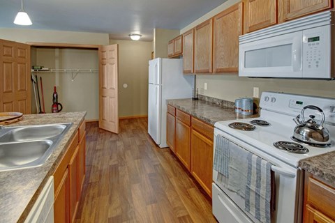 A kitchen with wooden cabinets and a white stove top oven.